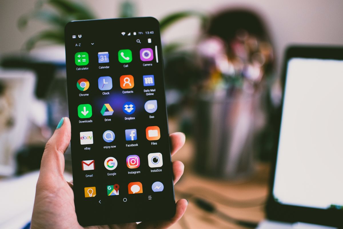 Mano sosteniendo un teléfono móvil con aplicaciones